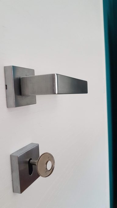 Metallo manico di una porta con serratura e chiave.